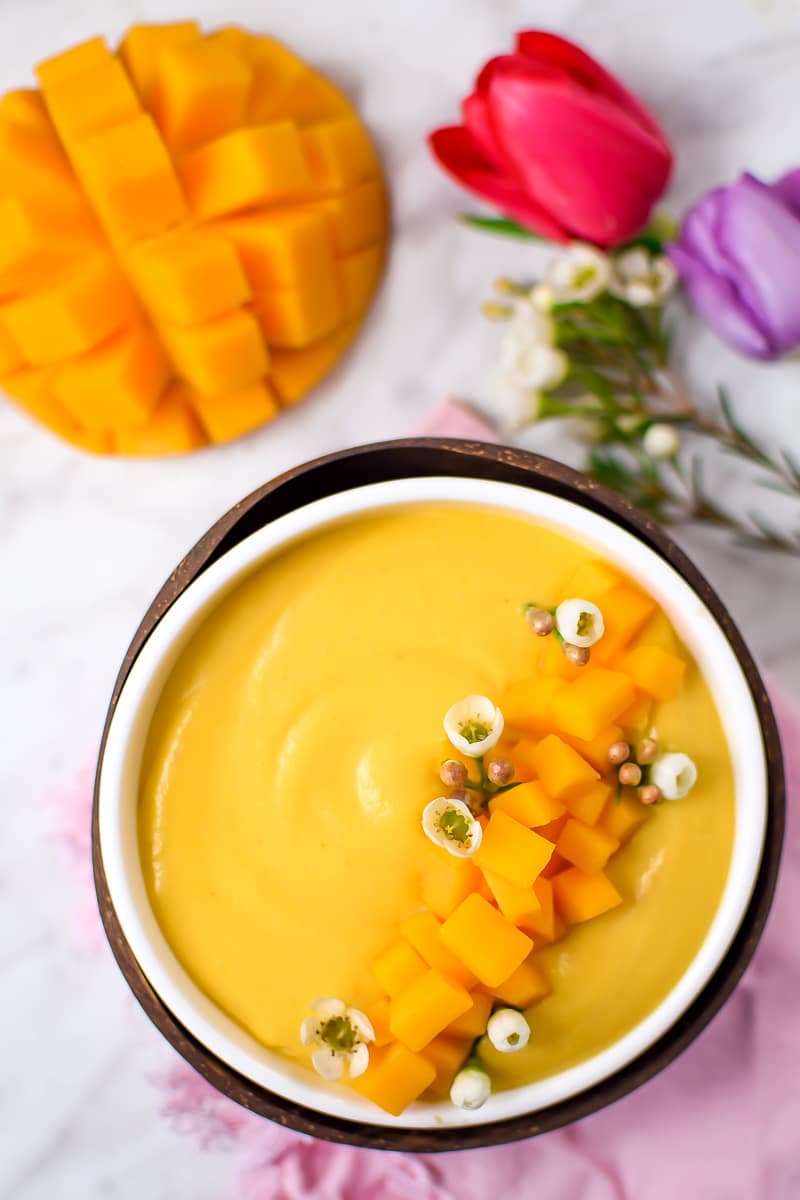 Springtime Mango Smoothie Bowl with Edible Flowers by Emily Kyle Nutrition