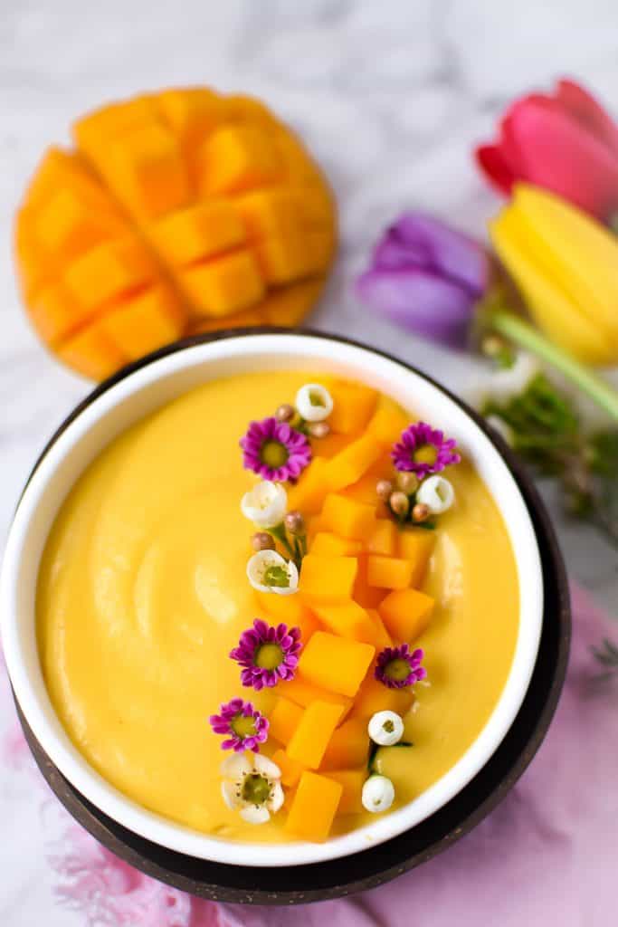 Springtime Mango Smoothie Bowl with Edible Flowers by Emily Kyle Nutrition
