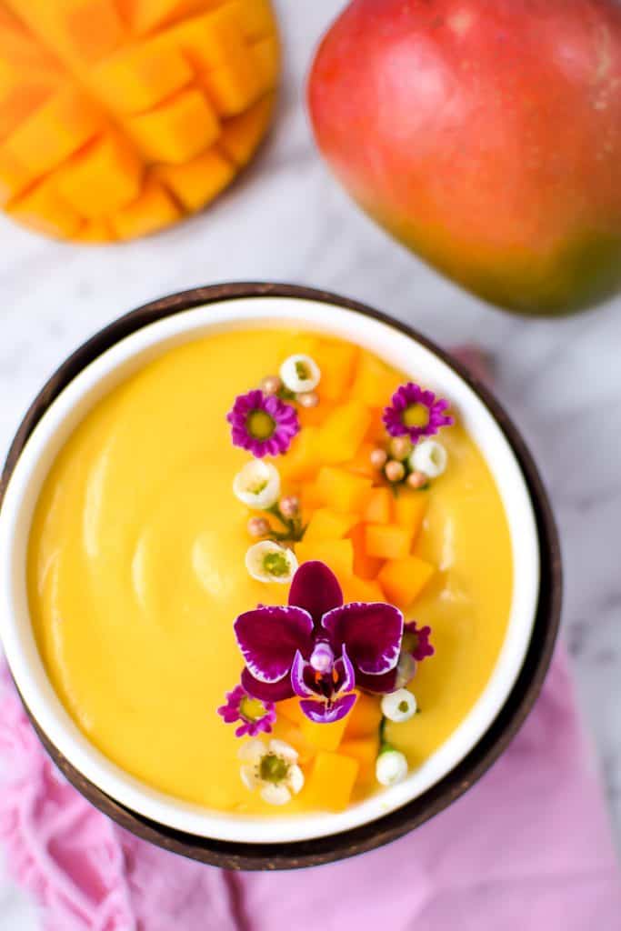 Springtime Mango Smoothie Bowl with Edible Flowers by Emily Kyle Nutrition