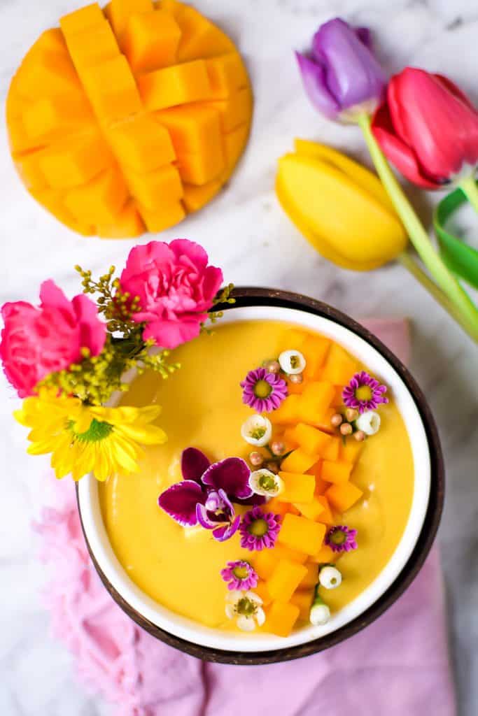 Springtime Mango Smoothie Bowl with Edible Flowers by Emily Kyle Nutrition