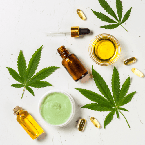 A picture of a white background with several tincture bottles and pills and cannabis leaves.
