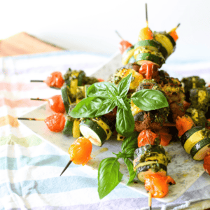 A picture of veggie skewers on a plate.