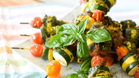 A picture of veggie skewers on a plate.