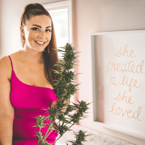 A picture of Emily Kyle holding a cannabis plant.