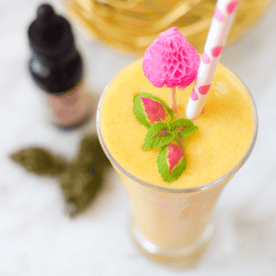 Tropical fruit and veggie cannabis smoothie in a glass.