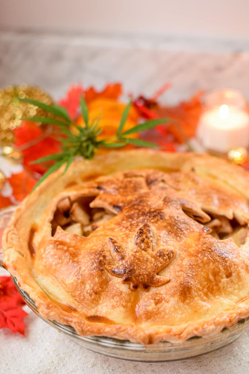 A picture of a slice of cannabis apple pie with the whole pie in the background