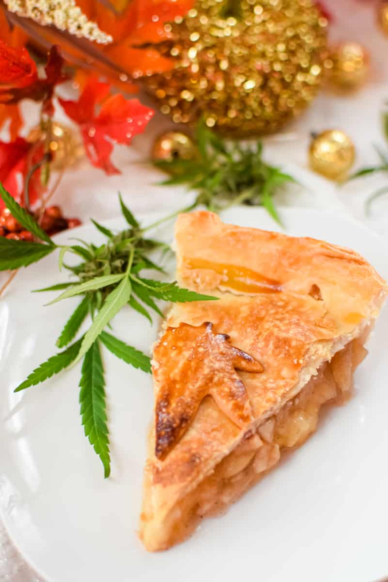 A white plate with a slice of cannabis apple pie on top