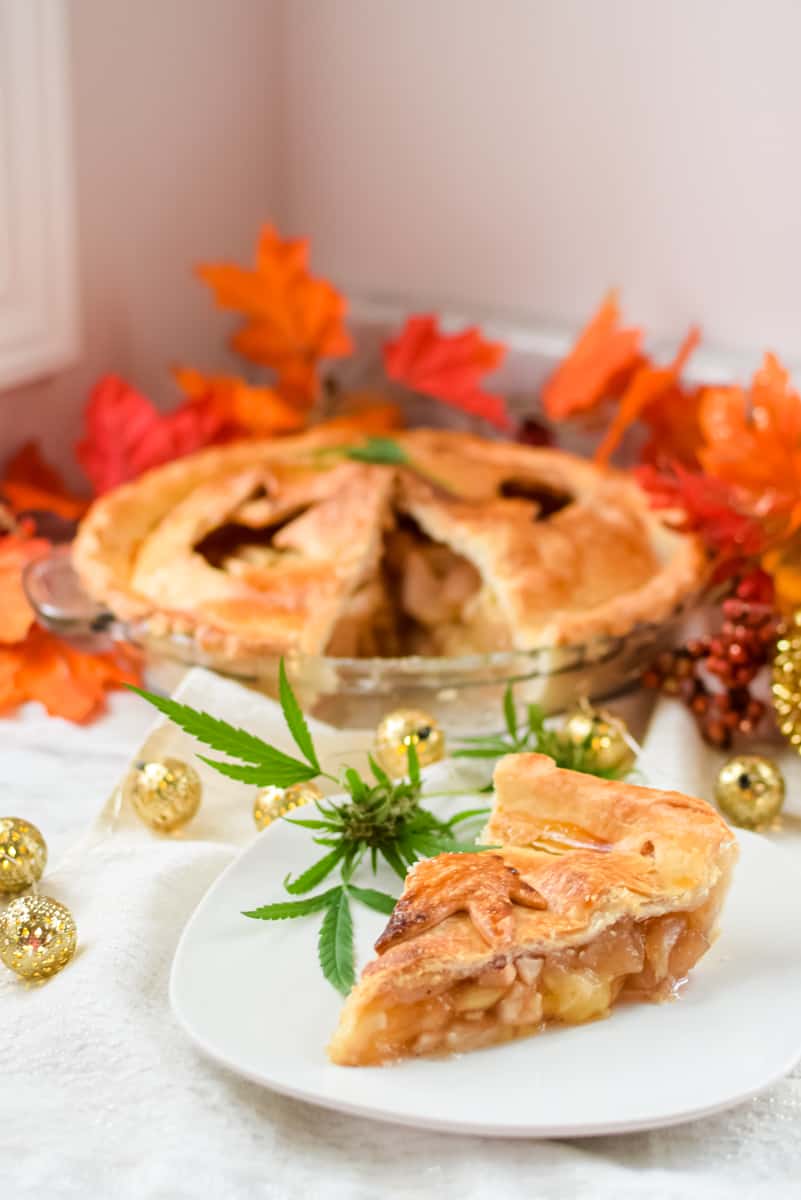 A picture of a slice of cannabis apple pie with the whole pie in the background