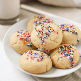 A picture of several Italian Spritz Cookies with Anise on a white plate.