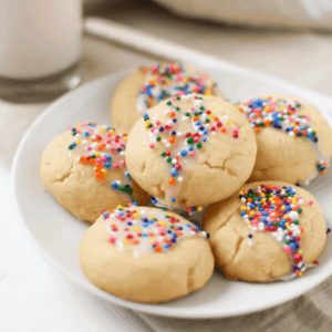 A picture of several Italian Spritz Cookies with Anise on a white plate.