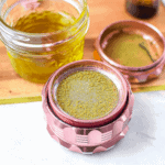 A picture of cannabis kief in a pink grinder.
