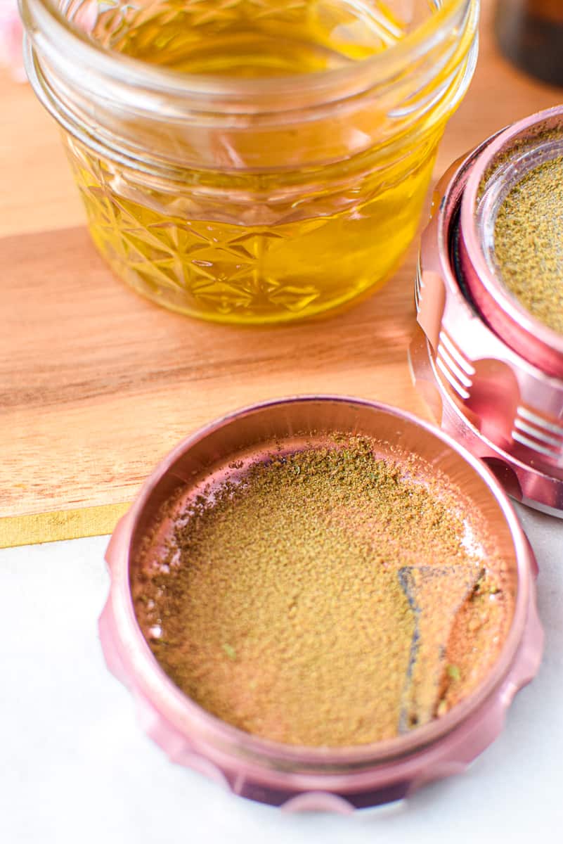 A picture of cannabis kief in a pink grinder. 