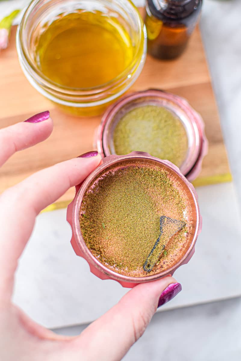 A picture of cannabis kief in a pink grinder.