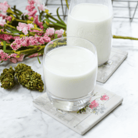 A white countertop with a glass of cannabis infused milk