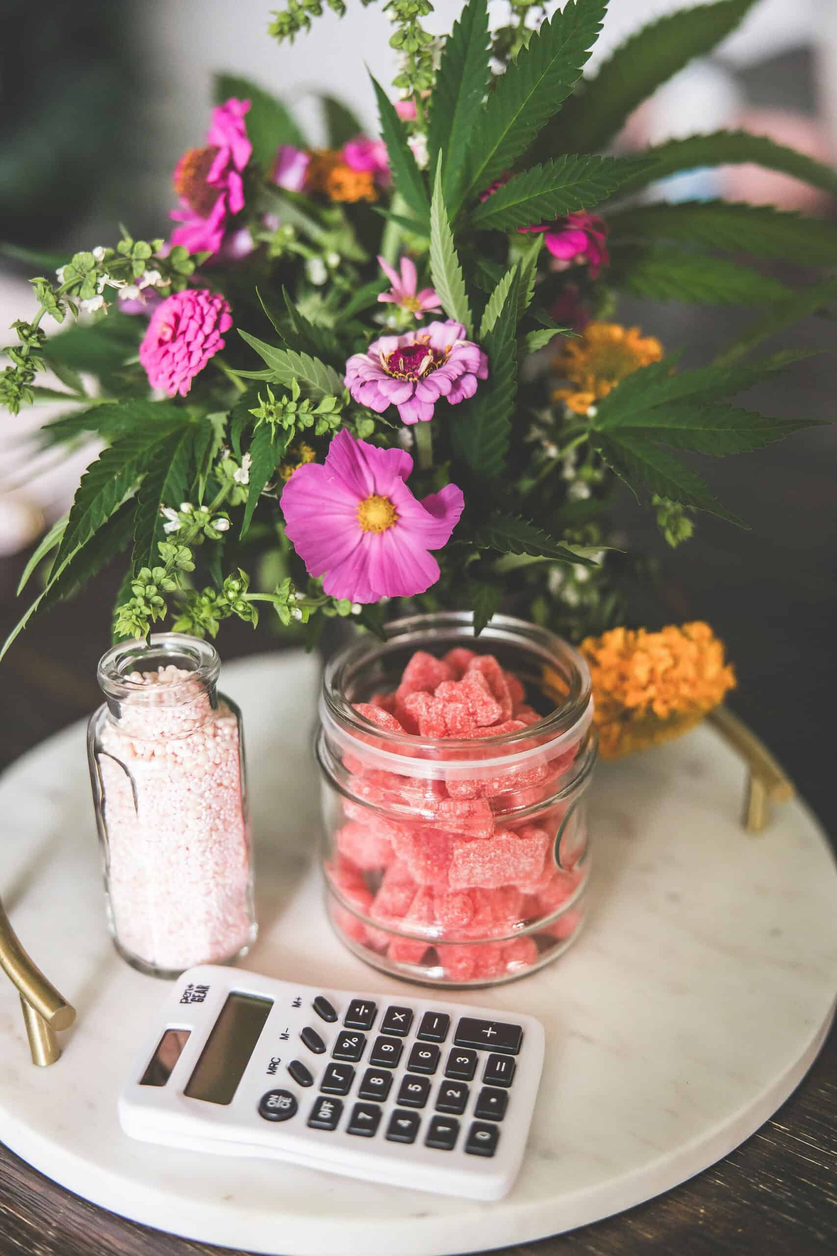 A picture of a white calculator and a gummy bear edible. 