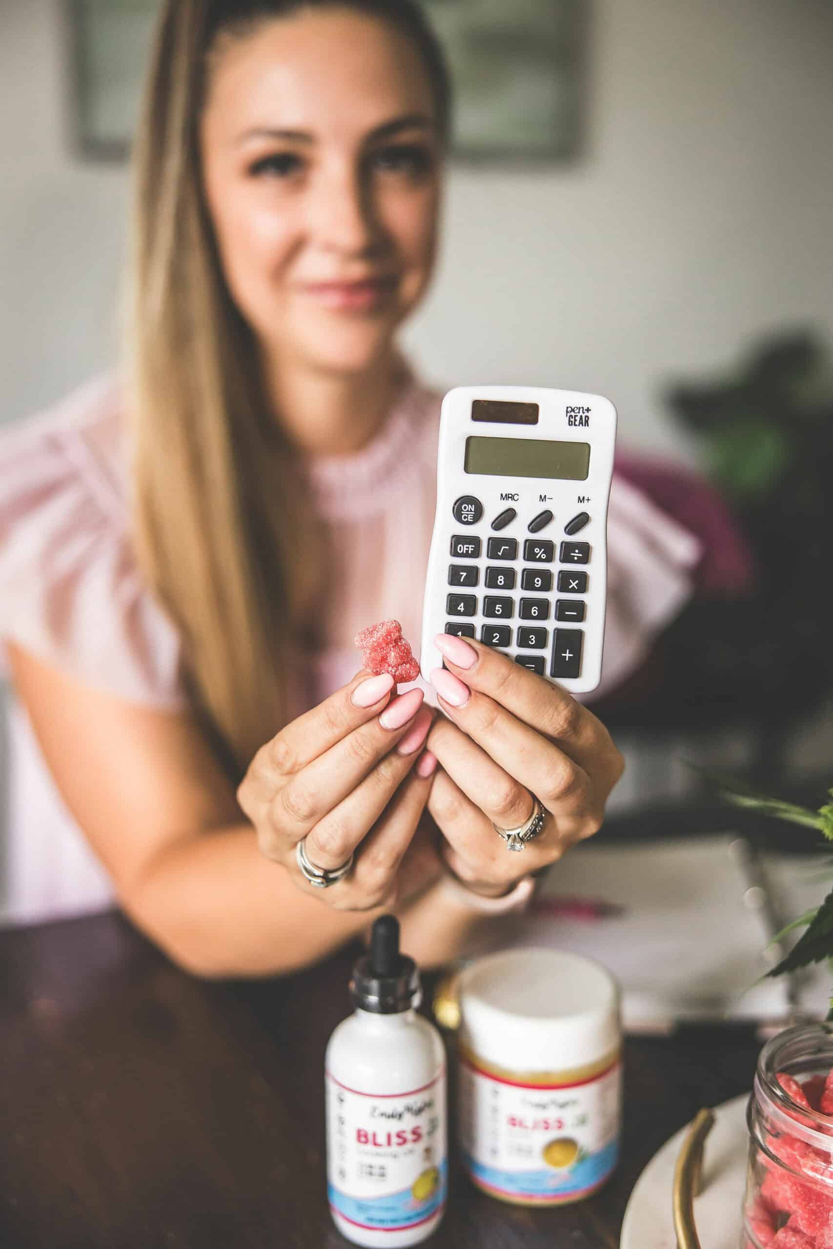 A picture of a white calculator and a gummy bear edible.