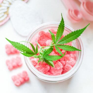 A picture of a container of pink gummies with a cannabis leaf on top.