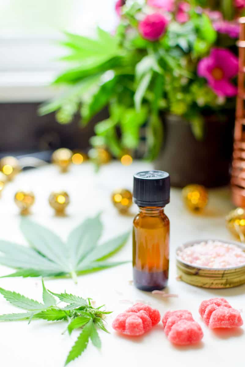 A picture of a tincture bottle among other cannabis edibles. 