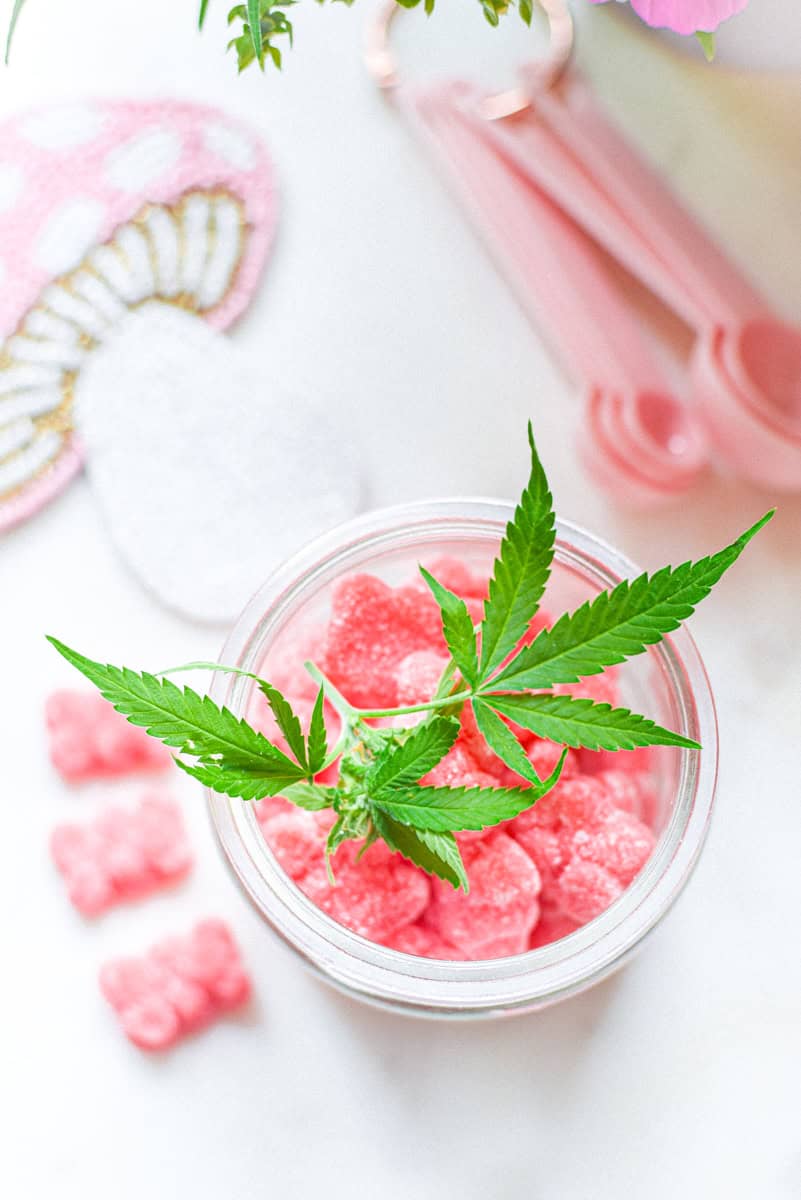 A picture of a container of pink gummies with a cannabis leaf on top.