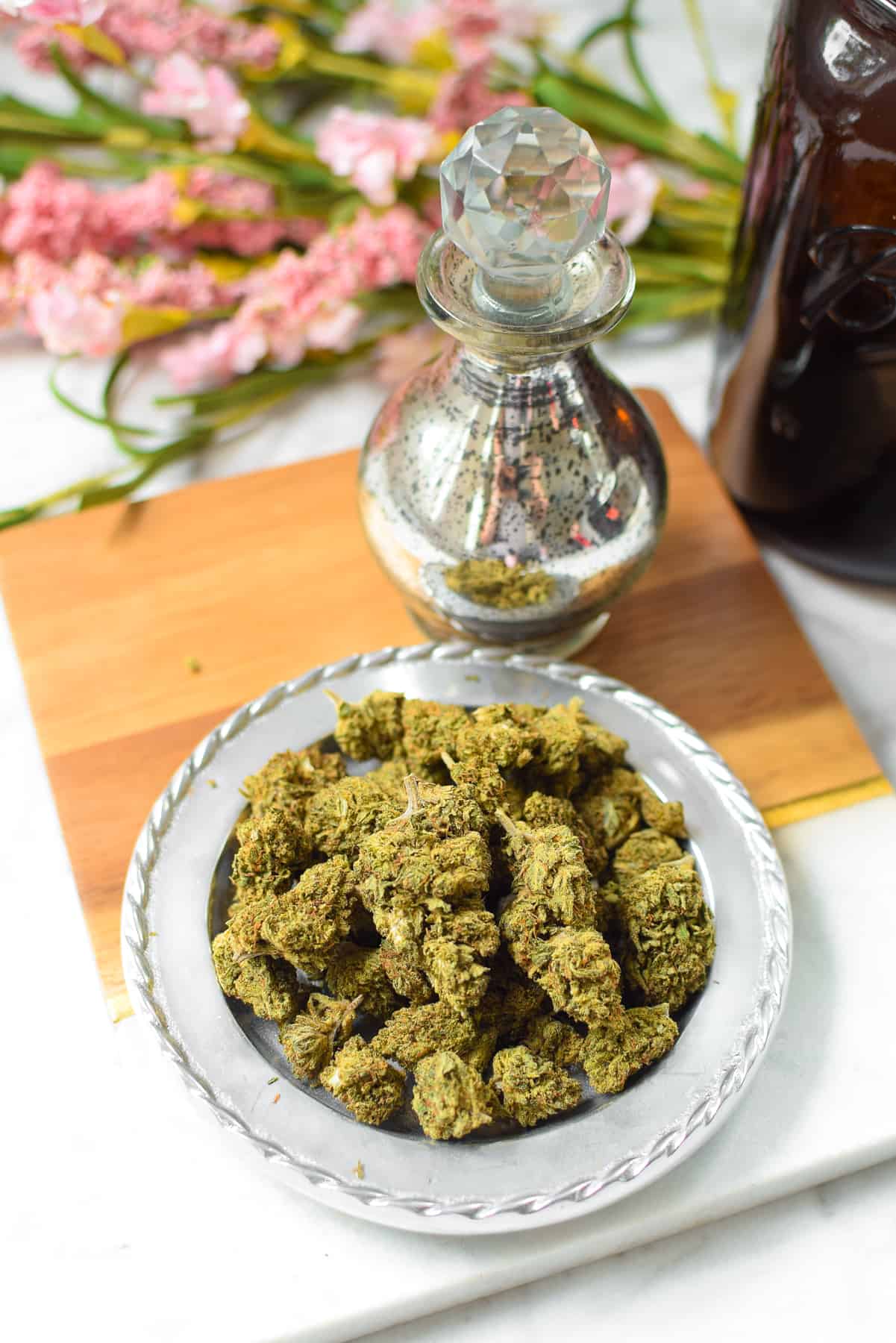 A shallow bowl of green cannabis flower
