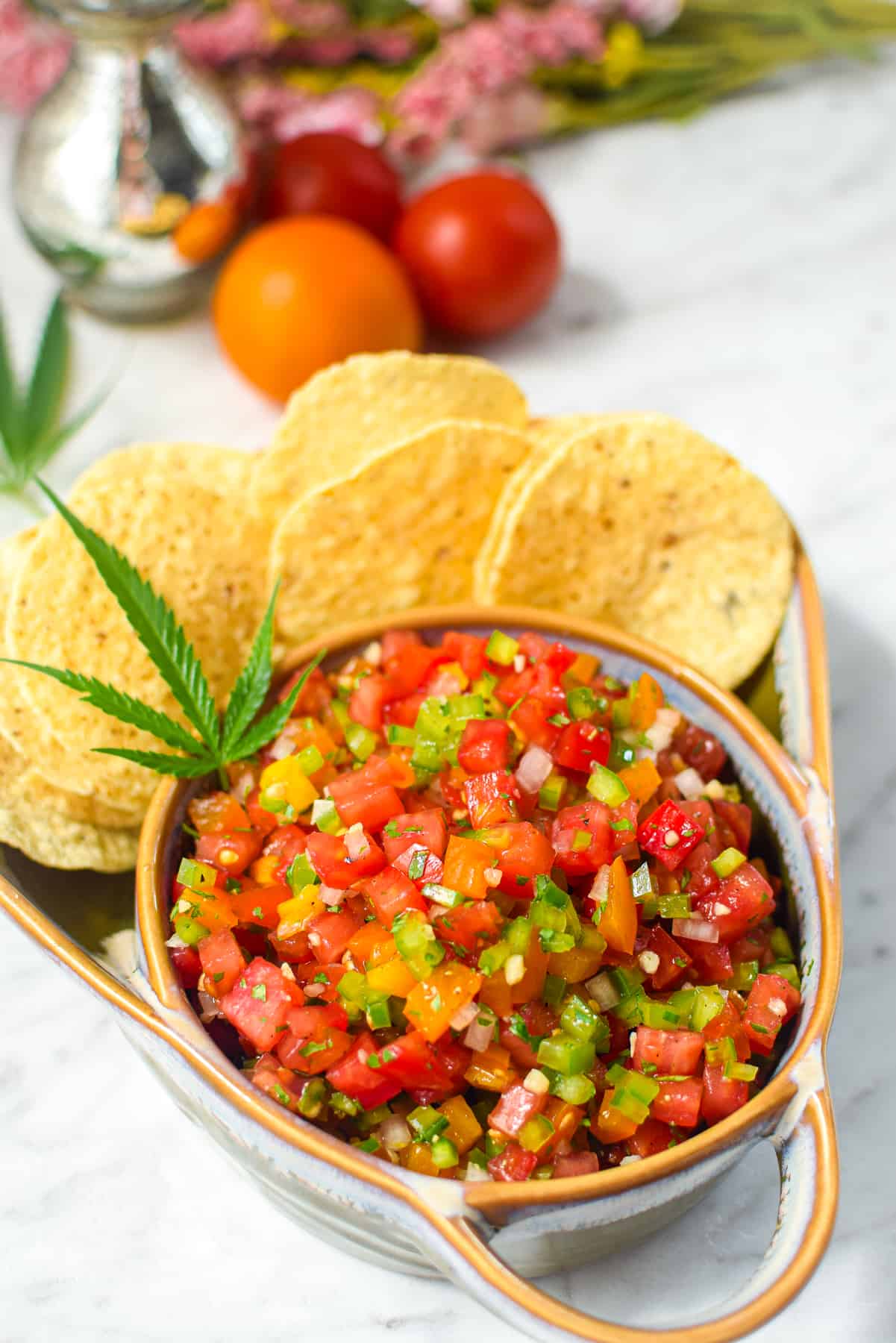 A finished bowl of cannabis infused salsa garnished with a cannabis fan leaf