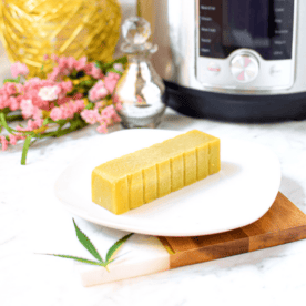 A picture of a stick of cannabutter on a white plate with an instant pot in the background