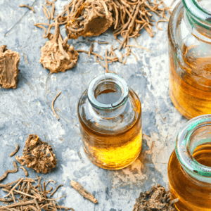 A picture of a rock surface with a glass bottle filled with cannabis root tincture