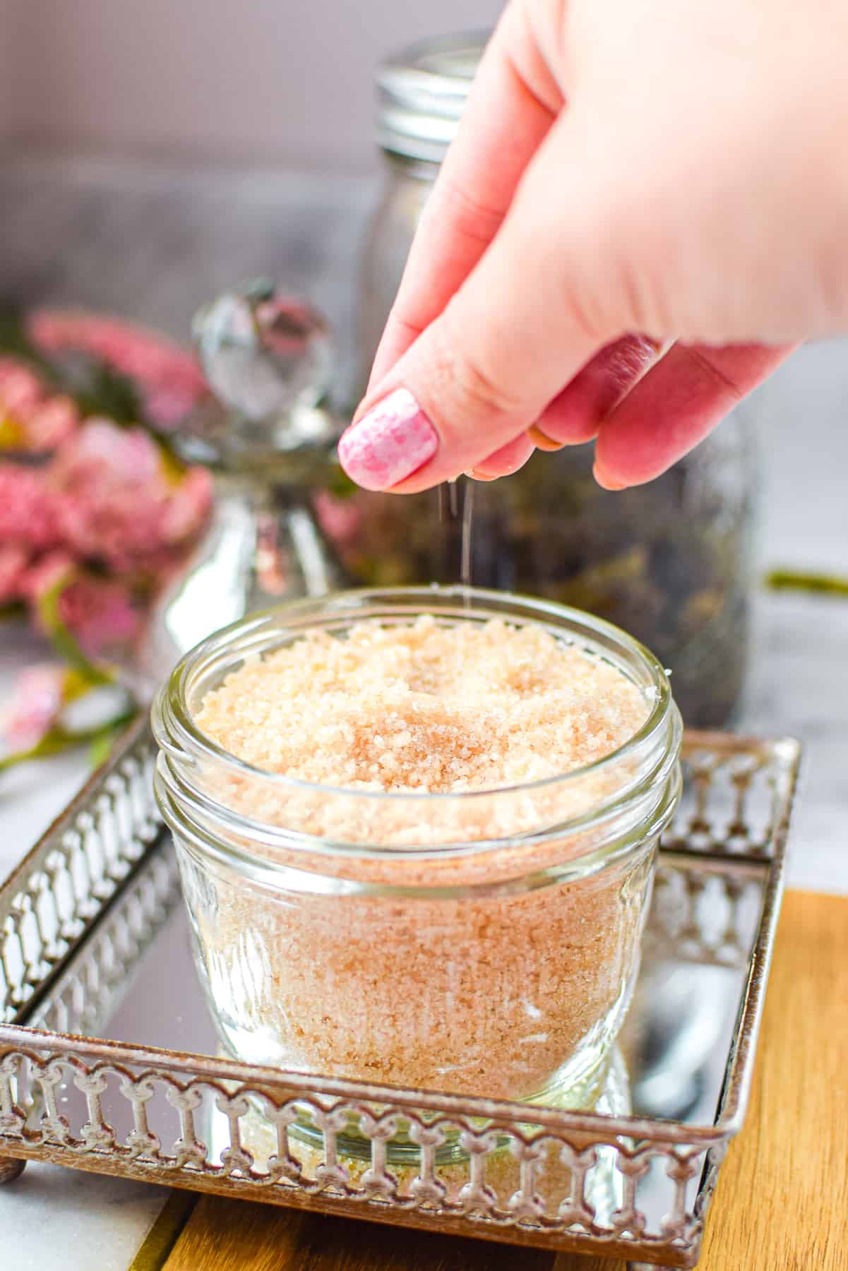 A hand sprinkling cannabis salt into a mason jar