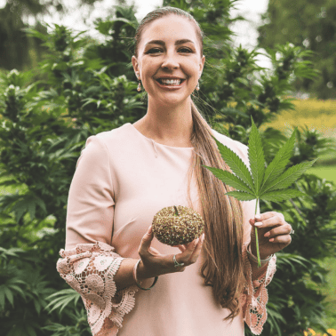 A picture of Emily Kyle holding a cannabis leaf.