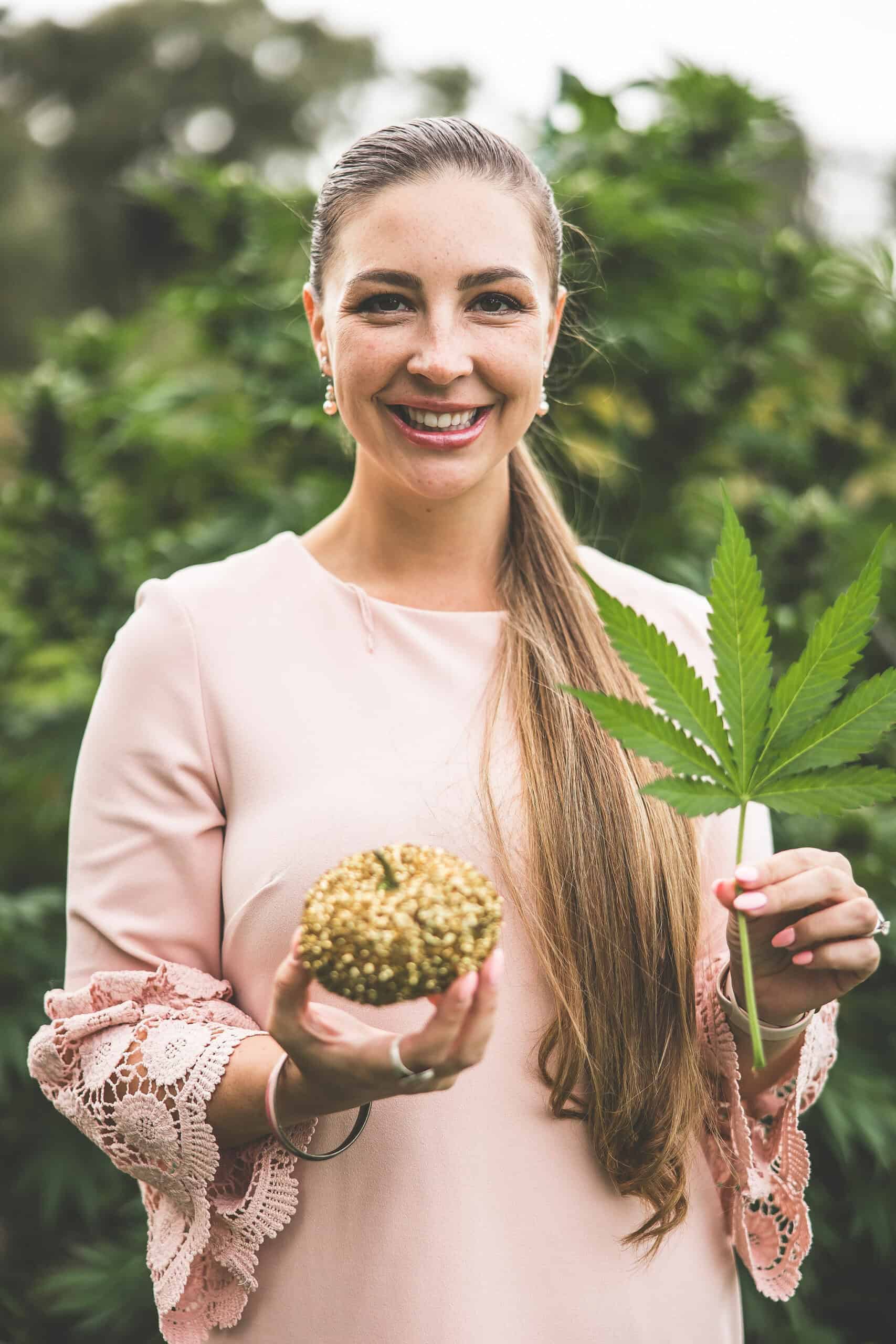 A picture of Emily Kyle holding a cannabis leaf.