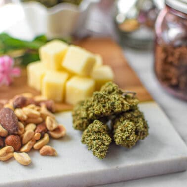 A picture of cannabis buds with high fat foods like cheese and nuts.