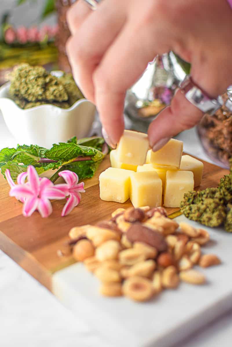 A picture of cannabis buds with high fat foods like cheese and nuts.