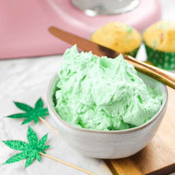 A white countertop with a bowl of green cannabis buttercream frosting