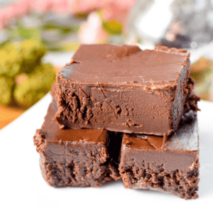 A white plate with stacked pieces of cannabis fudge.