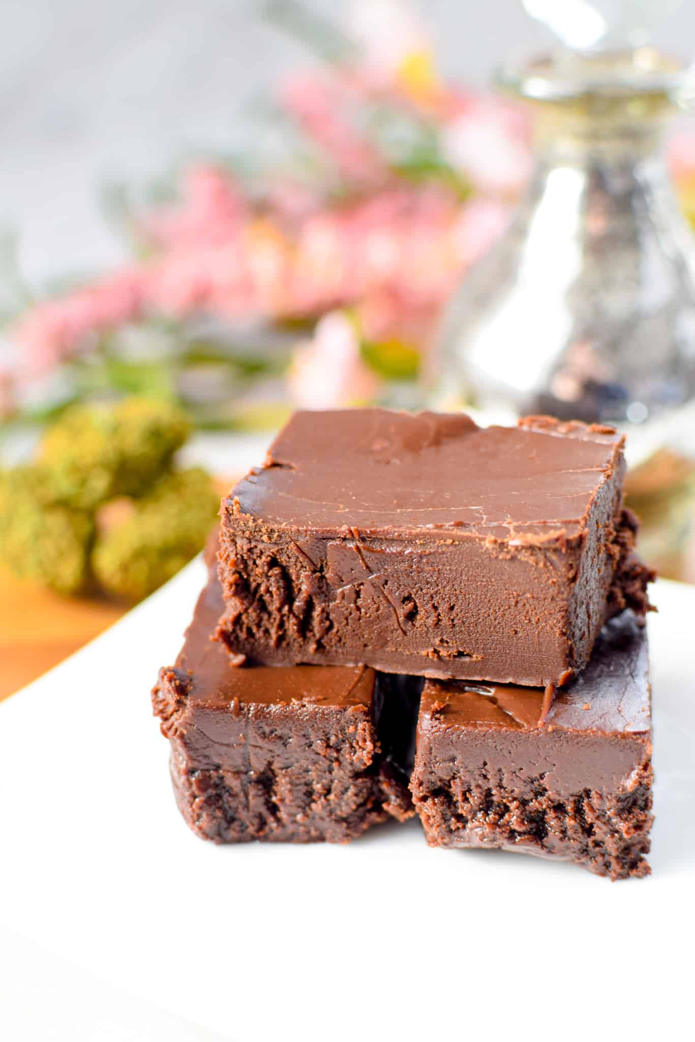 A white plate with stacked pieces of cannabis fudge.