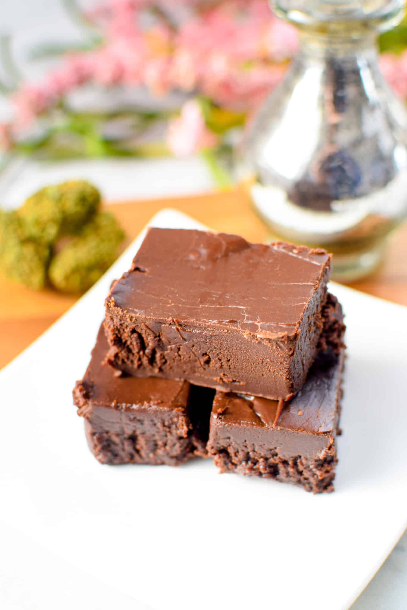 A white plate with stacked pieces of cannabis fudge.