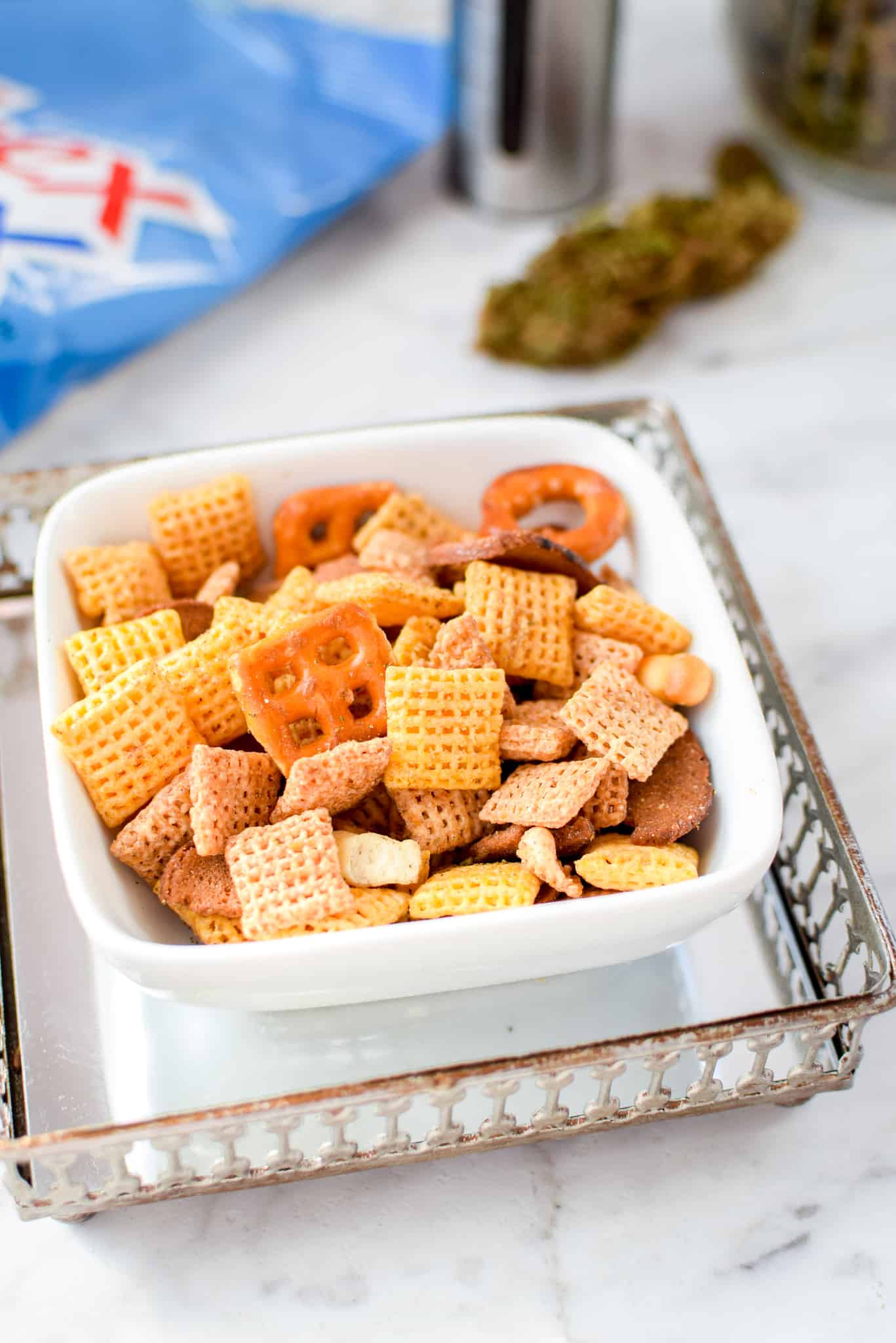 A picture of a while bowl containing cannabis chex mix.
