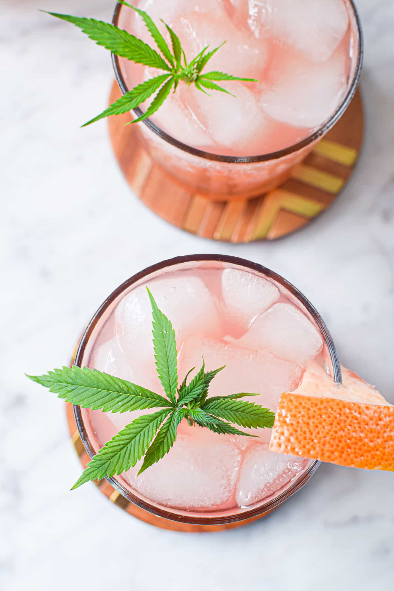 A picture of a glass of the prepared cannabis Paloma cocktail garnished with a cannabis leaf.