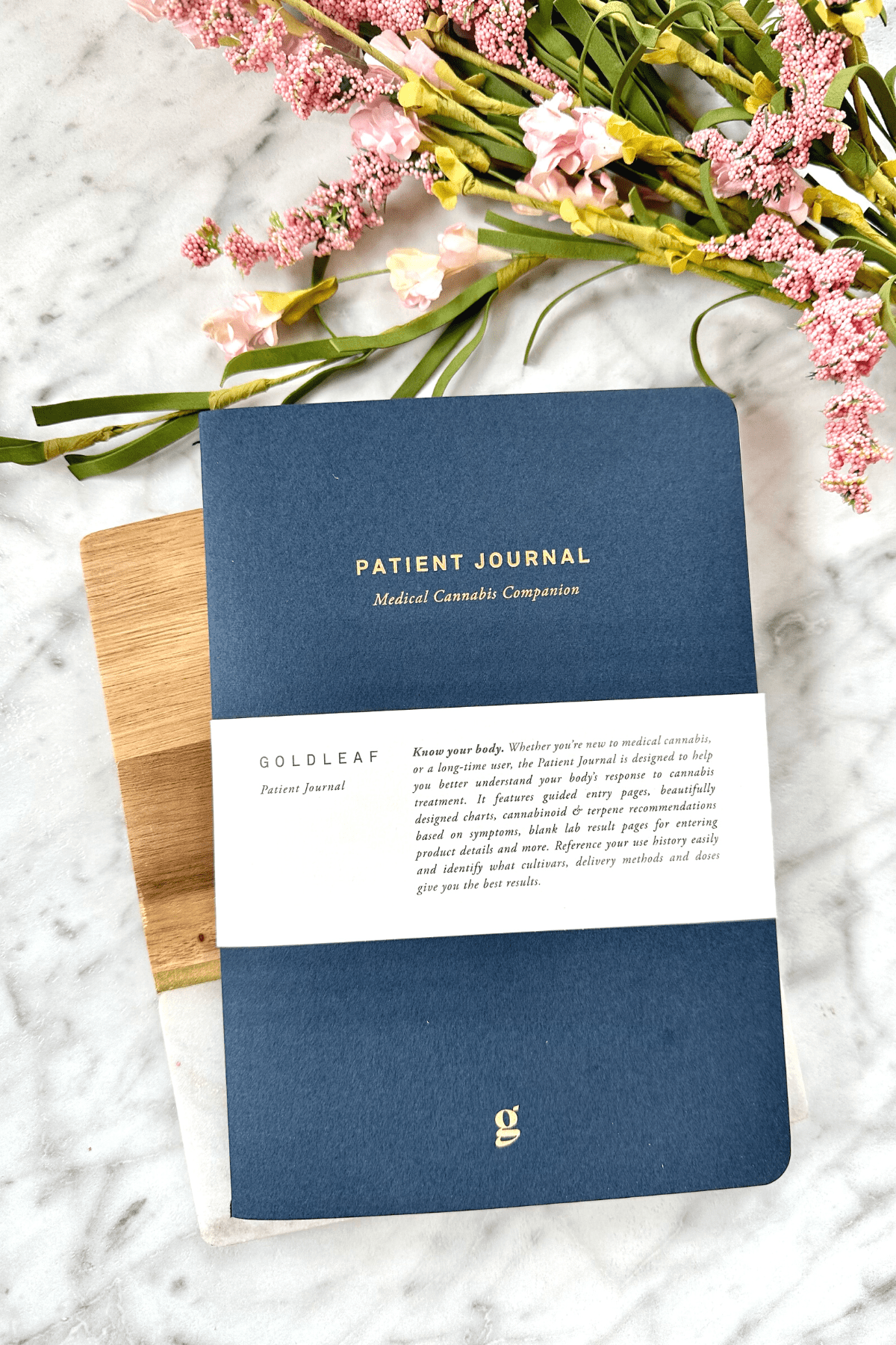 A picture of a Gold Leaf cannabis journal on a white counter top.