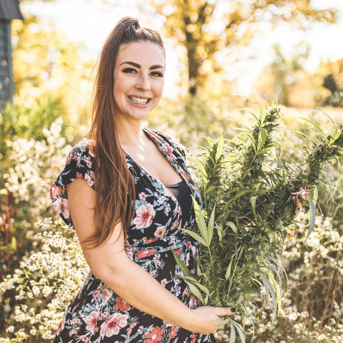 A picture of Emily Kyle holding cannabis plants.