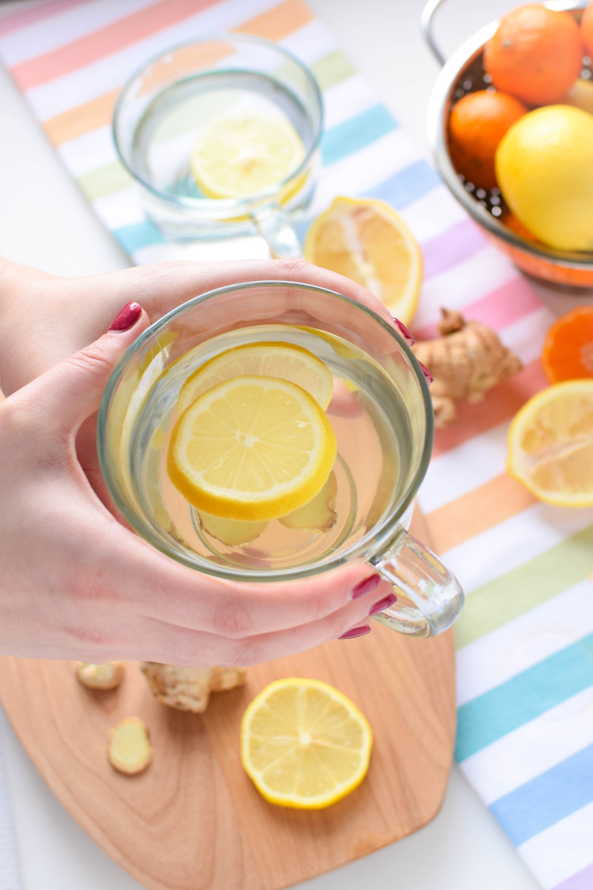 A picture of a clear mug full of lemon, ginger, honey and warm water.