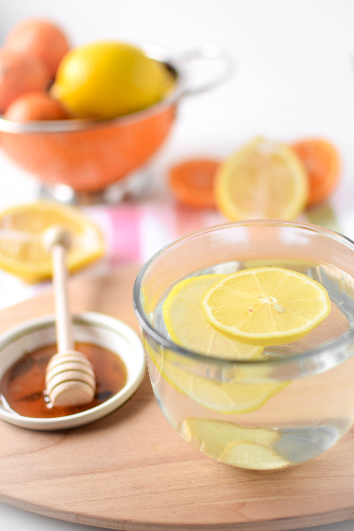 A picture of a clear mug full of lemon, ginger, honey and warm water.