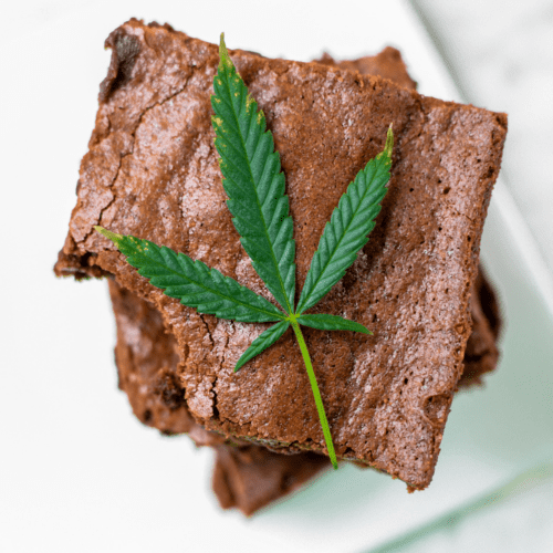 A picture of a stack of cannabis brownies with a cannabis leaf.