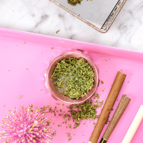 A picture of a pink cannabis grinder on a pink tray.
