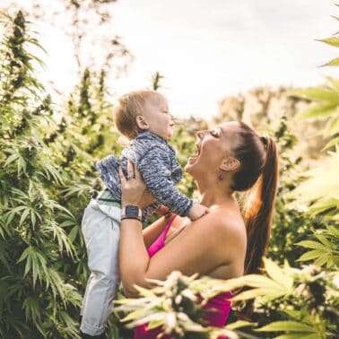 A picture of Emily Kyle and her baby in a cannabis garden.