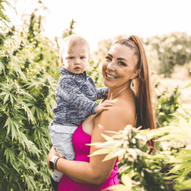 A picture of Emily Kyle and her baby in a cannabis garden.