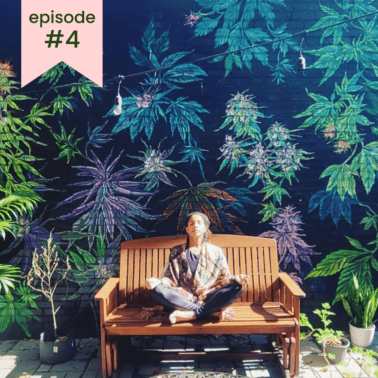 A picture of Sharyn Lustre sitting on a wooden bench in front of a cannabis mural.