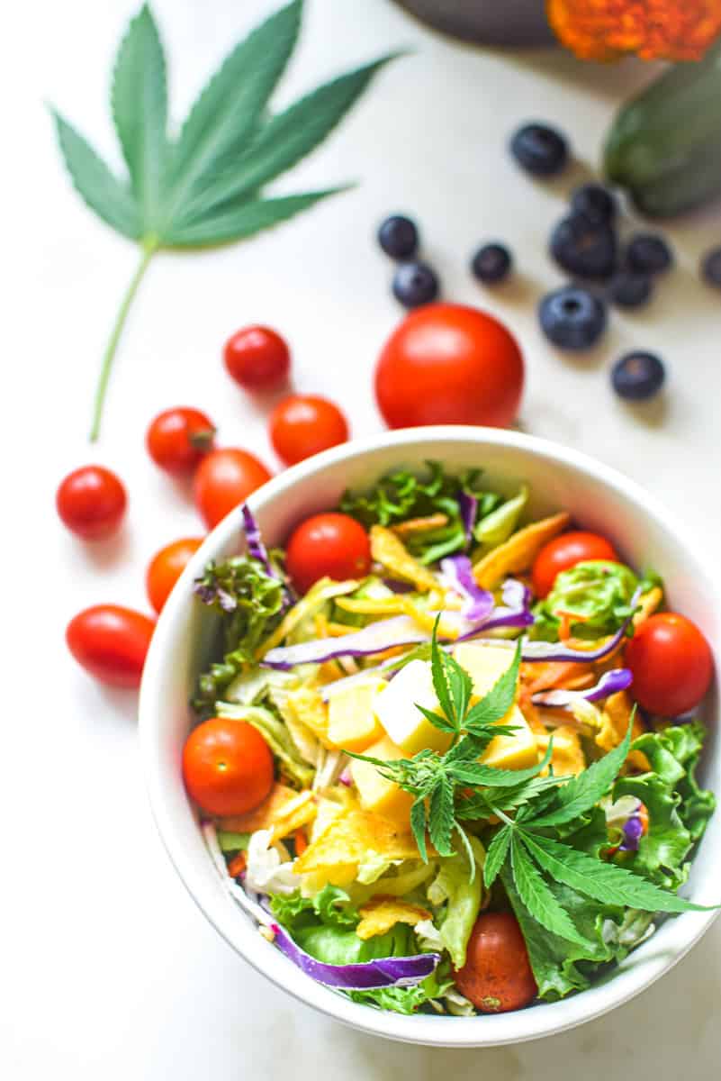 A picture of a salad with a cannabis leaf in the background with text that says cannabis to support a keto and low carb lifestyle.