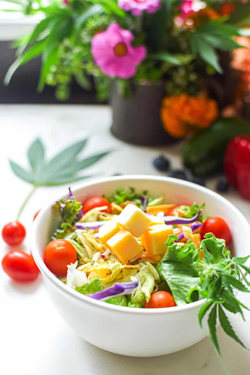 A picture of a salad with a cannabis leaf in the background with text that says cannabis to support a keto and low carb lifestyle.