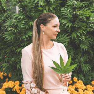 A picture of Emily Kyle holding a cannabis leaf.